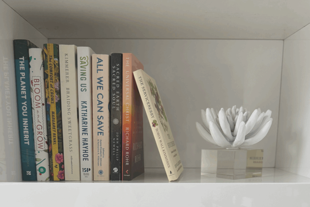 Climate and environment-focused books on a shelf with white flower decoration